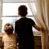 kids stand at window looking out