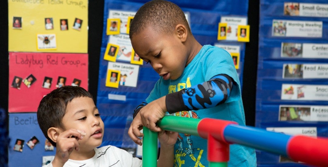 Pre-K students work on a structure in class