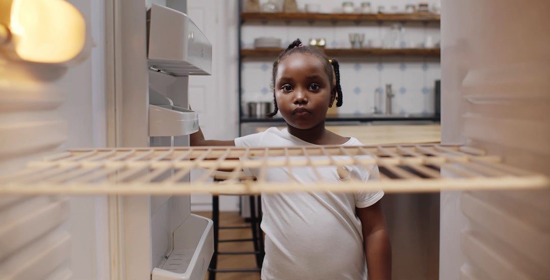 child looking inside empty fridge