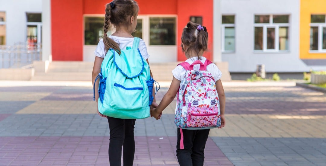 Two students walk to elementary school classes.