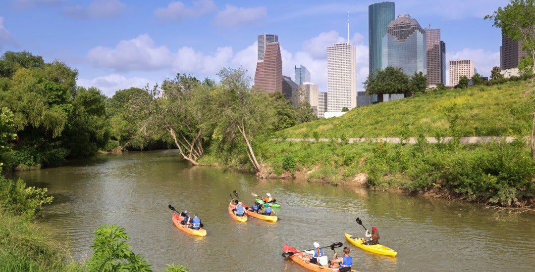 Kayakers paddle along Buffalo Bayou near downtown Houston.