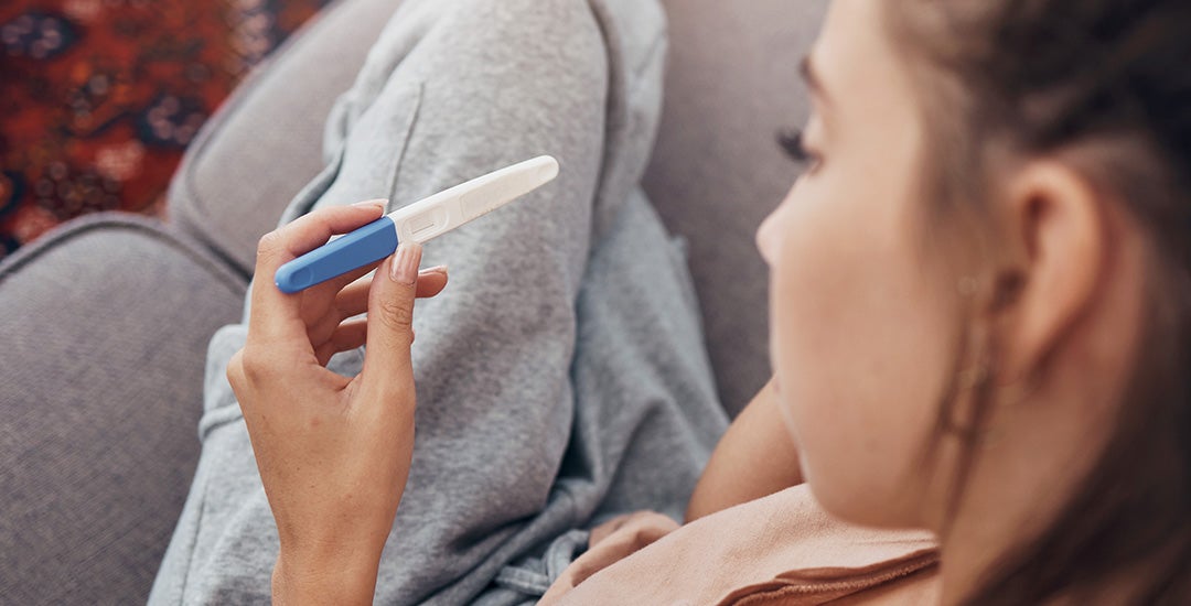 woman looking at a pregnancy test