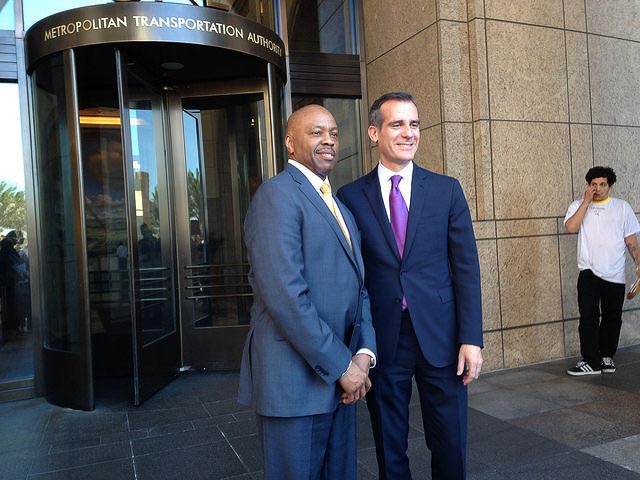 Two men standing in front of the Metropolitan Transportation Authority