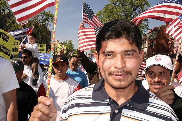 Man holding an American flag during an immigration rally
