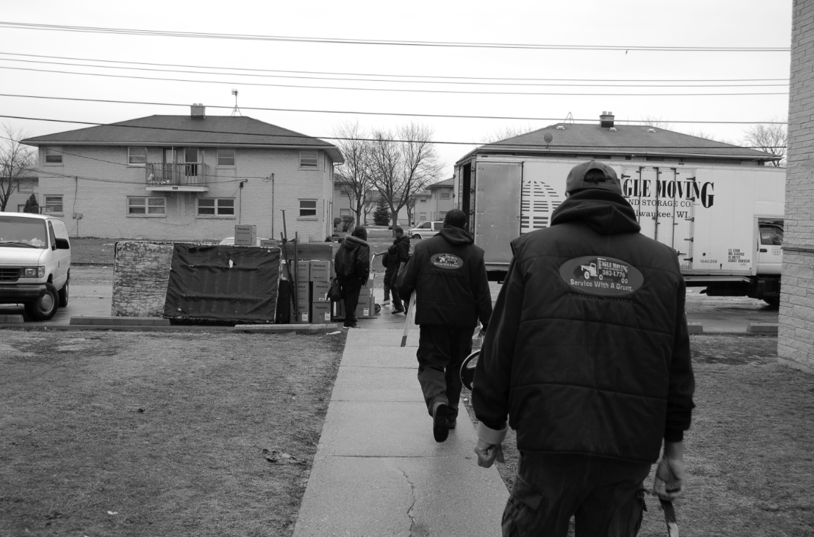 Black and white photo of men and a moving truck