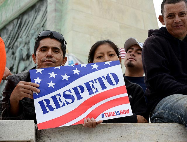 Man holding sign with the American flag on it saying, "Respeto"