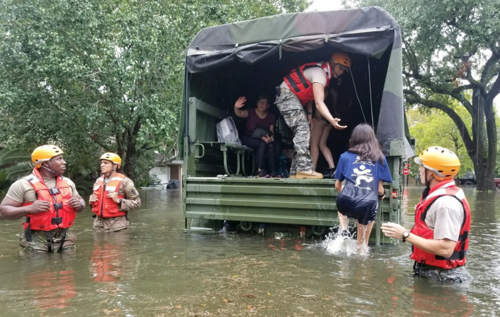 Man helping woman into a truck during a flood