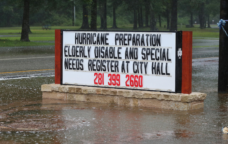 Sign during flood saying "Hurricane preparation" help lines