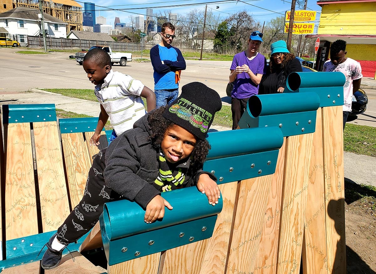 young boy playing at Third Ward Chess Park on Star Bench