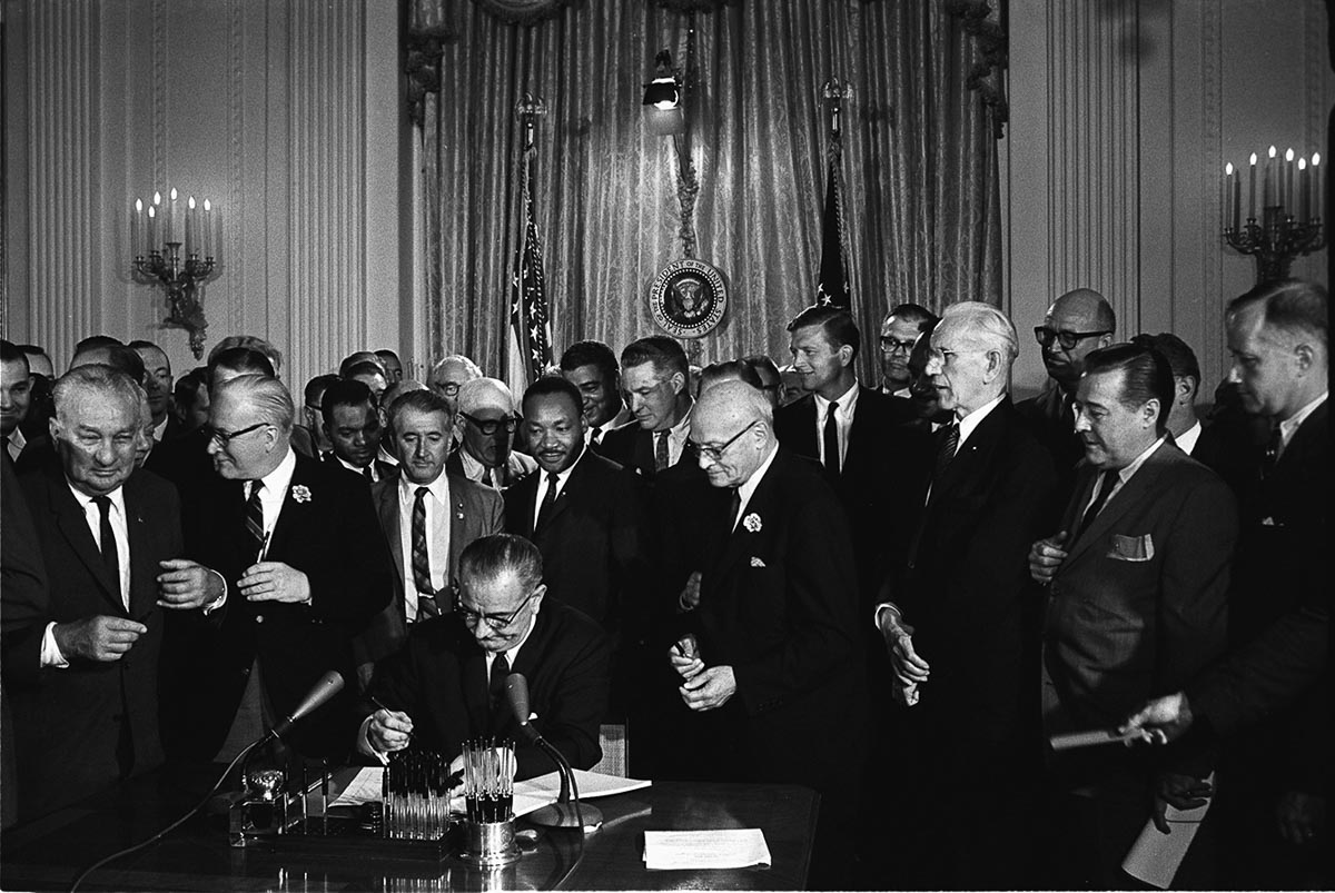 Lyndon Johnon signs the Civil Rights Act in 1964