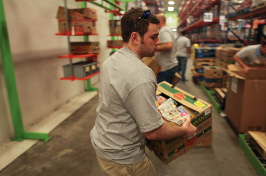 Image of a volunteer carrying a box of food