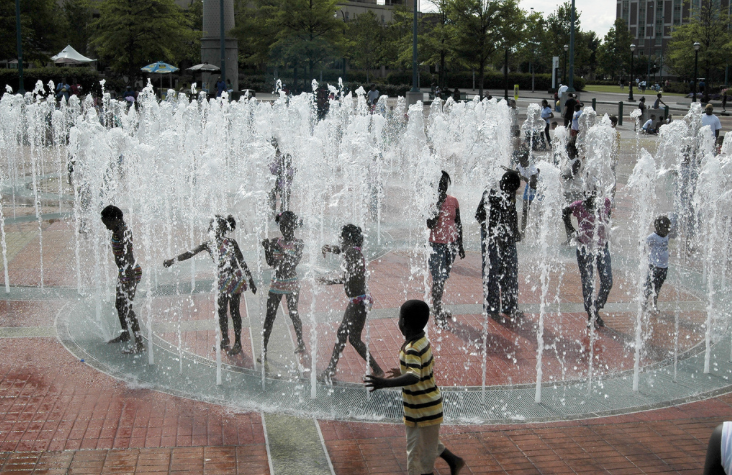 Kids playing in a splash pad in a city park