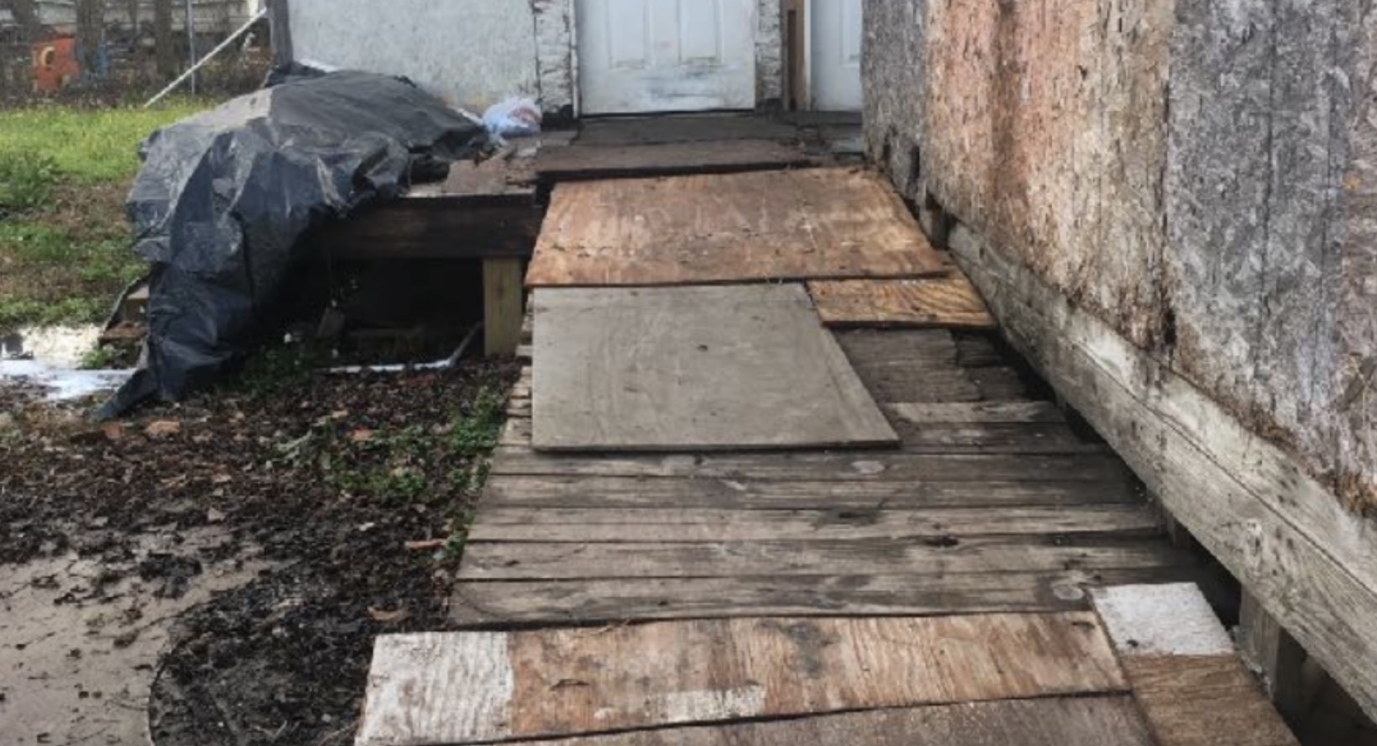 A makeshift wheelchair ramp leading to a house door