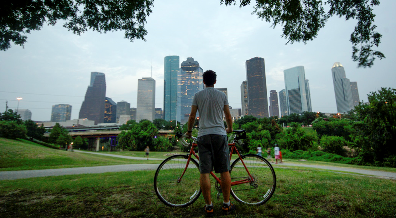 Man with his bike looking at the Houston skyline