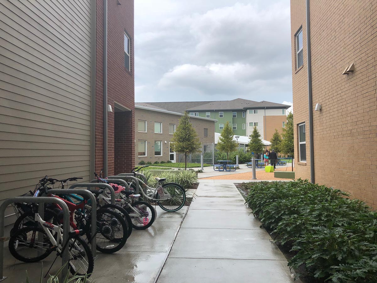 A walkway with bike parking leading to central courtyard