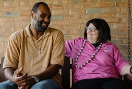 Two people share a moment together on a patio swing. 