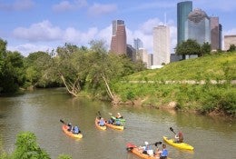 Kayakers paddle along Buffalo Bayou near downtown Houston. 
