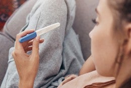woman looking at a pregnancy test