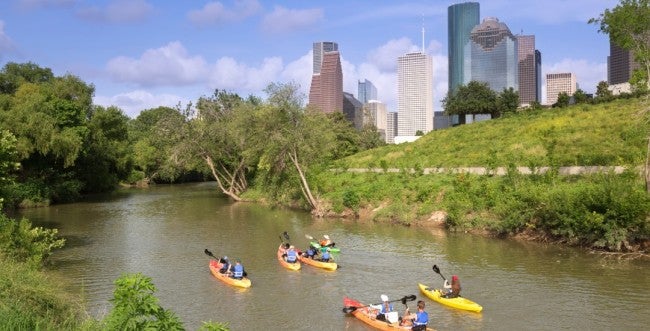 Kayakers paddle along Buffalo Bayou near downtown Houston.