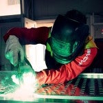 A craftsman welds aluminum sheets together.