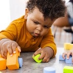 infant playing with blocks