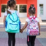 Two students walk to elementary school classes.