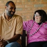Two people share a moment together on a patio swing.