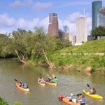 Kayakers paddle along Buffalo Bayou near downtown Houston.