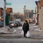 Image of person carrying shopping bags at street corner in Brooklyn, New York