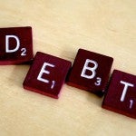 Scrabble letters spelling out "debt"