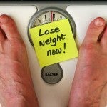 Man on a scale saying "Lose weight now!"