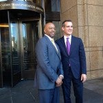 Two men standing in front of the Metropolitan Transportation Authority