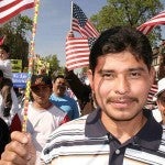 Man holding an American flag during an immigration rally