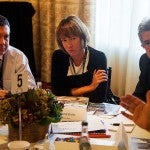 Woman listening at a table with men