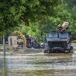 Photo of a truck moving through high flood waters