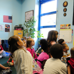 Classroom of students listening to a teach read a book