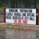 Sign during flood saying "Hurricane preparation" help lines
