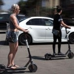 Women riding Bird electronic scooters