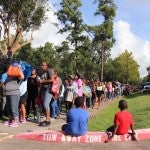 Residents wait in a long line outside for the fair