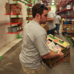 Image of a volunteer carrying a box of food