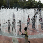Kids playing in a splash pad in a city park