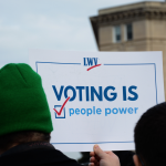 Man holding Voting Is People Power sign