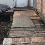 A makeshift wheelchair ramp leading to a house door