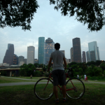Man holding his bike in front of Houston skyline