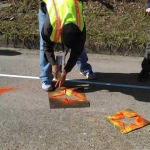 Men spray painting stars on a road