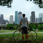 Man with his bike looking at the Houston skyline