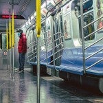 Man with face covering riding the subway