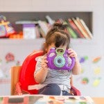 Child using toy camera in school