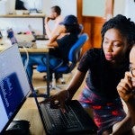 Woman in and office with a man at a computer
