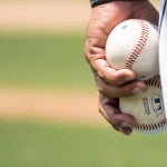 man holding baseball balls